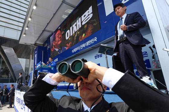 Security personnel stand guard in Gumi, North Gyeongsang, as Democratic Party presidential candidate Lee Jae-myung holds a campaign rally in the region on May 13. [YONHAP]