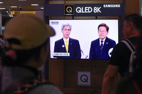 Citizens watch the broadcast of the first presidential debate at a waiting room in Seoul Station in Jung District, central Seoul on May 18 where Lee was attacked for his economic policy. [YONHAP]