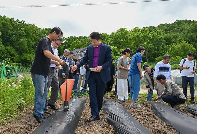 파종식 참가자들이 21일 인천 강화도에서 백태 콩을 심고 있다. 강화도(인천)=신석현 포토그래퍼