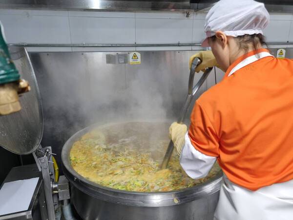 인천 한 중학교 급식실에서 조리실무사 A씨가 음식을 조리하기 위해 삽을 들고 국수 육수를 젓고 있다. 정성식 기자