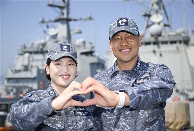 율곡이이함 기관장 임재우 중령(진)과 정조대왕함 주기실장 김보아 소령이 율곡이이함(오른쪽 배)의 갑판에서 ‘손하트’를 만들고 있다. 율곡이이함 옆에는 정조대왕함이 부부처럼 사이좋게 정박돼 있다. 해군