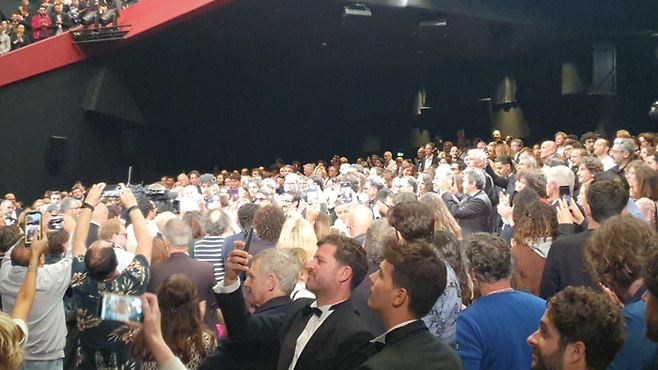 20일(현지시간) 오후 칸영화제 뤼미에르 대극장 ‘단순한 사고’ 상영 직전의 모습. 자파르 파나히 감독이 입장하자 곳곳에서 카메라 플리시가 터졌습니다. 사진 중앙 약간 좌측의 선글라스를 착용한 인물이 자파르 파나히 감독입니다. 자파르 파나히 감독이 영화를 연출하며 받은 정권의 핍박 때문인지, 이날 관객들은 상영 직전 모두가 기립해 2분간 기립박수를 감독에게 보냈습니다. 상영 직후가 아닌 상영 직전 기립박수가 나오는 건 이례적인 일입니다. [김유태 기자]