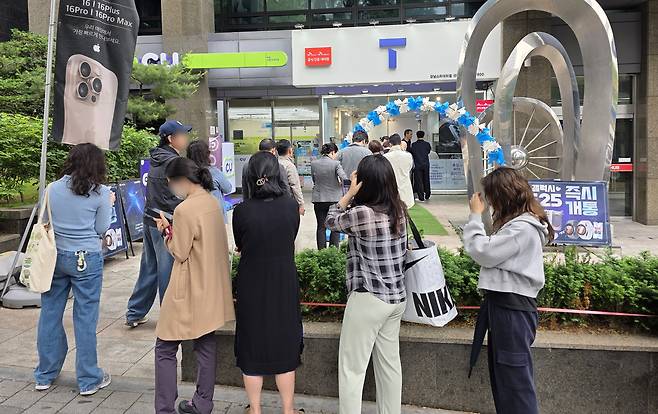 지난 20일 서울 시내 한 SK텔레콤 공식인증 대리점 앞에 고객들이 유심 교체를 위해 길게 줄을 서 기다리고 있다.  [연합]
