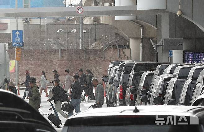 [제주=뉴시스] 우장호 기자 = 제주에 도착한 이용객들이 비를 피해 이동하고 있다. 2025.05.09. woo1223@newsis.com