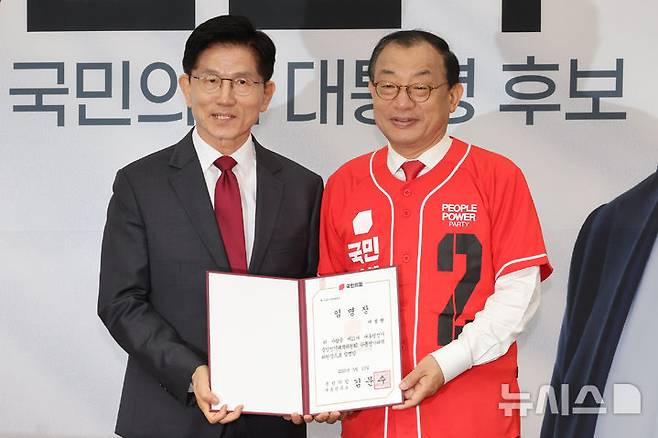 [서울=뉴시스] 조성우 기자 = 국민의힘 김문수(왼쪽) 대선후보가 15일 오전 서울 여의도 국회에서 열린 중앙선대위 회의 및 중앙선대위 임명장 수여식에서 이정현 전 새누리당 대표에게 공동선대위원장 임명장을 수여한 뒤 기념촬영하고 있다. 2025.05.15. xconfind@newsis.com