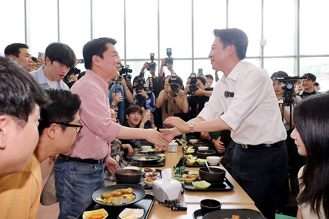 개혁신당 이준석 대선 후보가 21일 '학식먹자 이준석' 행사가 열린 경기 성남시 가천대학교 글로벌캠퍼스에서 행사에 참여한 국민의힘 안철수 의원과 만나 악수를 하고 있다. 성남=연합뉴스