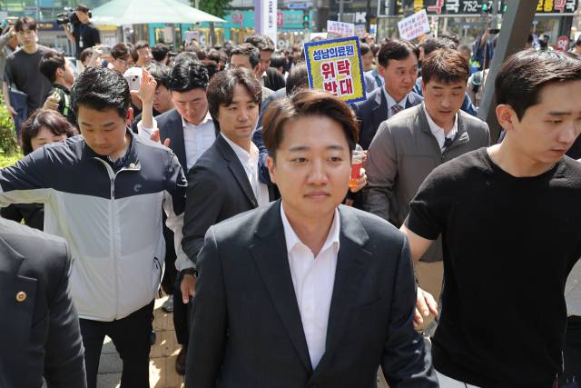 이준석 개혁신당 대선 후보가 21일 경기 성남의료원에 도착, 시민단체 회원들의 항의를 받으며 들어서고 있다. 연합뉴스