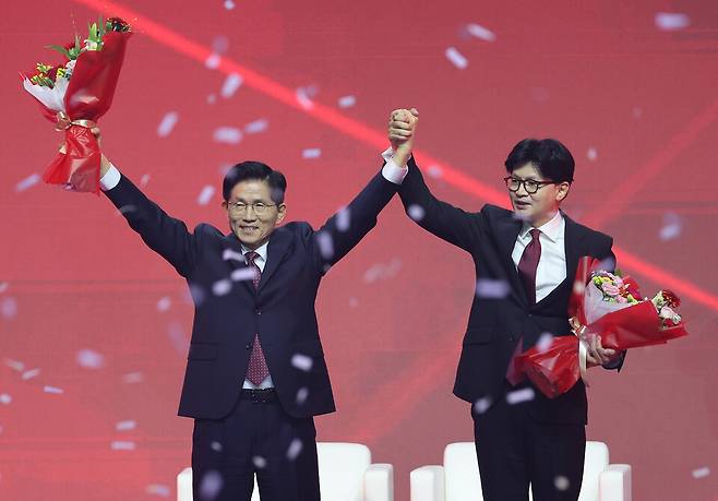 국민의힘 대선 후보로 선출된 김문수 후보가 3일 경기 고양시 킨텍스에서 열린 국민의힘 전당대회에서 꽃다발을 받은 뒤 한동훈 후보와 함께 인사하고 있다. ⓒ사진공동취재단