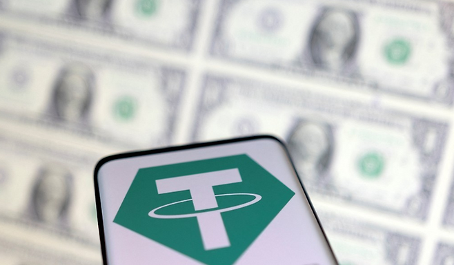 달러화 지폐 배경으로 촬영된 테더 로고 ⓒ연합뉴스