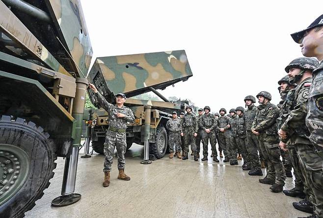 육군은 22일, 해외 주요 방산협력국 장병들을 대상으로 K-무기체계의 전술적 운용을 교육하는 '육군 국제과정' 현장 모습을 공개했다. 이번 훈련은 국제과정 최초로 천무 교육이 개설되었으며, 15일부터 2주간 폴란드 장병 16명이 교육훈련을 받고 있다. 사진은 폴란드군 교육생들이 교관들로부터 천무의 전술적 운용방법에 대한 설명을 듣고 있다. 육군 제공
