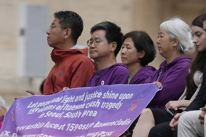 10·29 이태원 참사 유가족들이 21일(현지시간) 오전 바티칸 성 베드로 광장에서 열린  레오 14세 교황이 즉위 후 첫 일반인 알현식에 참석하고 있다. 유가족들이 이태원 참사 희생자 159명의 안식과 함께 진실 규명을 요구하는 보라색 현수막을 들고 있다. AP뉴시스