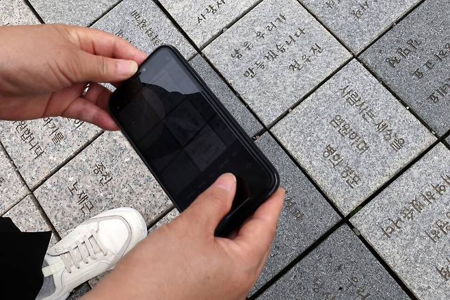 한 추모객이 22일 오전 경남 김해시 진영읍 봉하마을 고 노무현 전 대통령 묘역에서 “사람사는 세상을 염원하며”라고 적은 박석을 촬영하고 있다. 김영원 기자 forever@hani.co.kr