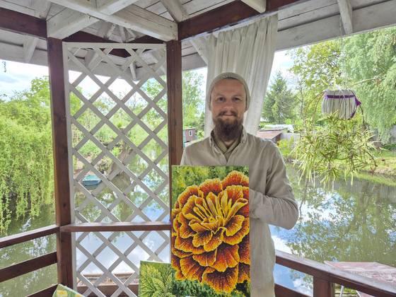 막심 기예라시모프가 우크라이나 전쟁 발발 이후 처음으로 완성했던 그림을 들어보이고 있다. 박현준 기자