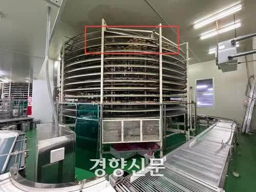 A photo of the accident site where a female worker in her 50s was killed after being caught in a conveyor belt at SPC Samlip’s bread factory in Siheung, Gyeonggi Province, on May 19. Taken shortly after the accident, it shows finished bread products (marked with a red outline) on the machine, just before the packaging stage. / Courtesy of the Siheung Fire Station