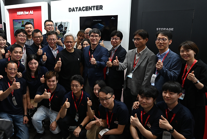 Jensen Huang, CEO of Nvidia, joins SK hynix employees and leadership for a photo during his unannounced visit to the company's booth at Computex 2025 in Taipei, Taiwan, Tuesday. (Yonhap)
