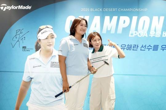 유해란(왼쪽)이 자신의 퍼터를 들고 팬과 기념 촬영을 하고 있다. /테일러메이드