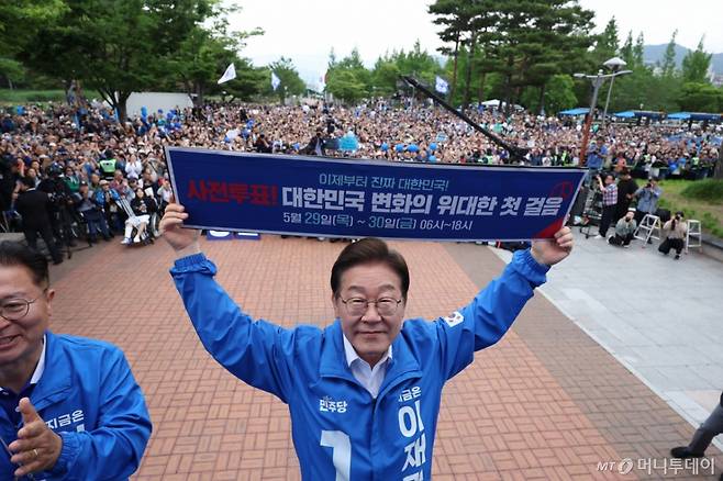 (양산=뉴스1) 이재명 기자 = 이재명 더불어민주당 대통령 후보가 22일 오후 경남 양산시 양산워터파크공원에서 열린 유세에서 '사전투표! 대한민국 변화의 위대한 첫 걸음'이라고 적힌 현수막을 들어보이고 있다. (공동취재) 2025.5.22/뉴스1  Copyright (C) 뉴스1. All rights reserved. 무단 전재 및 재배포,  AI학습 이용 금지. /사진=(양산=뉴스1) 이재명 기자