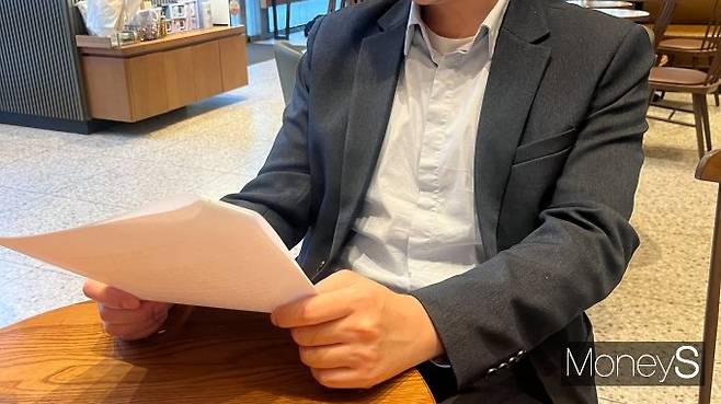 이상혁씨(가명·33)는 결혼을 앞두고 경제적 부담을 느끼고 있다. 사진은 결혼 준비 관련 서류를 살펴보는 이씨. /사진=김동욱 기자