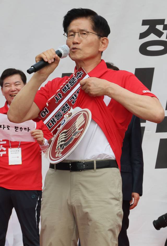 김문수 국민의힘 대선 후보가 22일 경기 광명시 철산로데오거리에서 열린 유세에 참석해 웃옷을 들어 보이며 방탄복을 입지 않았다고 말하고 있다.  연합뉴스
