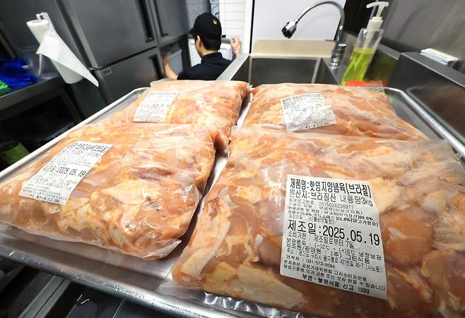 서울 시내 치킨 판매점에서 점주가 냉장고에서를 열어 재고를 점검하고 있다. [연합]