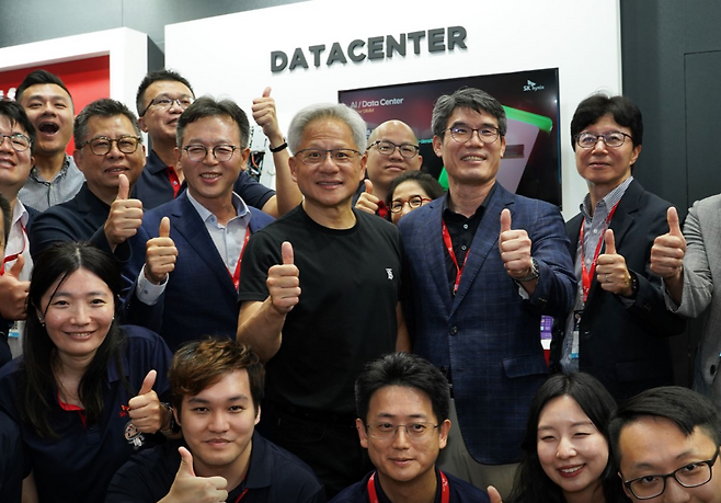 젠슨 황 엔비디아 최고경영자(CEO)가 지난 20일 대만 타이베이에서 열린 IT 전시회 ‘컴퓨텍스 2025’에서 SK하이닉스 부스를 깜짝 방문해 임직원들과 기념촬영하고 있다. [SK하이닉스 SNS]