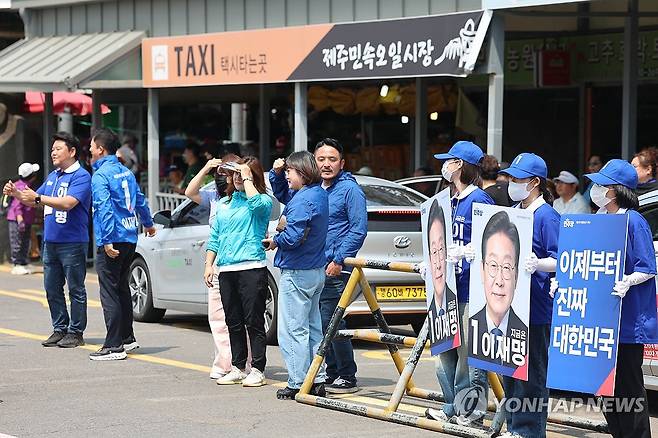 제주민속오일시장서 민주당 첫 유세 (제주=연합뉴스) 박지호 기자 = 6·3 대통령선거 공식 선거운동 첫날인 12일 오전 제주시 민속오일시장에서 더불어민주당 제주선대위 관계자들이 이재명 후보 지지를 호소하고 있다. 2025.5.12 jihopark@yna.co.kr