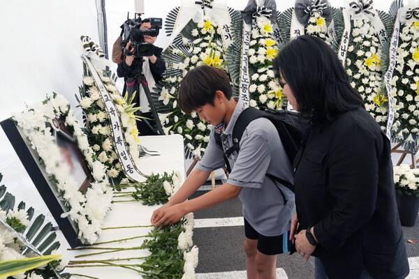 23일 오후 제주도교육청에 마련된 분향소. A씨 영정사진 앞에 한 학생이 국화를 놓고 있다.
