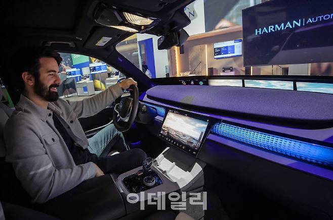 각 좌석에 장착된 우퍼와 스피커를 개별 제어할 수 있는 ‘하만카돈 앱’과 재생중인 음악과 연동해 차량 내 조명 효과를 제공하는 ‘오라 라이팅(Aura Lighting)’을 체험하는 모습. (사진=삼성전자)