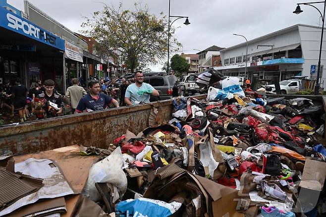 호주 동부 지역에서 집중 호우로 인해 대규모 홍수가 발생해 거리가 침수되고 주택이 파괴됐다. 사진은 23일(현지시간) 뉴사우스웨일스주 중북부 타리에서 자원봉사자들이 현지 주민들 도와 홍수 피해를 입은 상점들을 청소하고 있는 모습. 2025.05.23 ⓒ AFP=뉴스1 ⓒ News1 최종일 선임기자