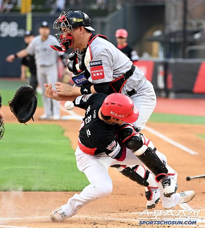 공을 떨어뜨리는 장성우와 홈플레이트를 찾는 박찬호의 발