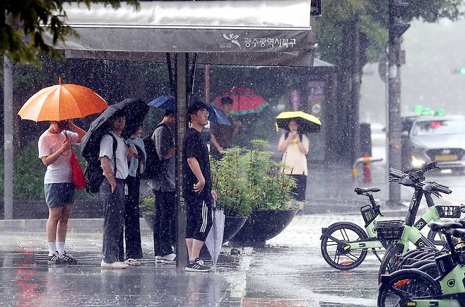 2024년 8월 21일 태풍 ‘종다리’의 영향으로 내린 소나기로 광주광역시 북구 용봉동 전남대학교 후문에서 학생들이 그늘막 아래 비를 피하고 있다. /뉴스1