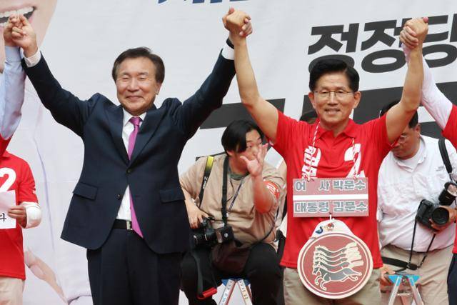 김문수(오른쪽) 국민의힘 대통령 후보가 22일 오후 경기 광명시 철산로데오거리에서 열린 유세 도중 자신에 대한 지지를 선언한 손학규(왼쪽) 전 바른미래당 대표 등의 손을 잡고 인사하고 있다. 연합뉴스