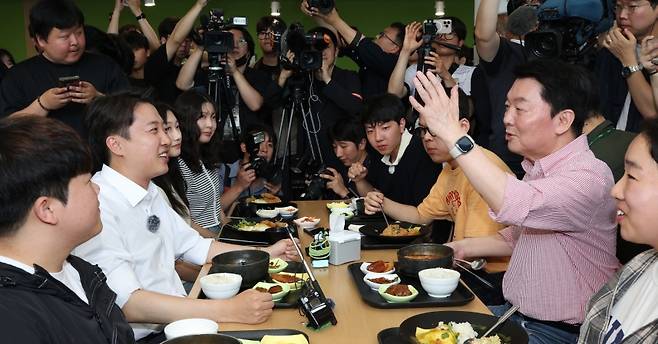 이준석 개혁신당 대선 후보(왼쪽)와 안철수 국민의힘 의원이 21일 경기 성남시 수정구 가천대학교 글로벌캠퍼스 학생식당에서 만나 이야기를 나누고 있다. (안철수 의원 페이스북 캡처) 있다.