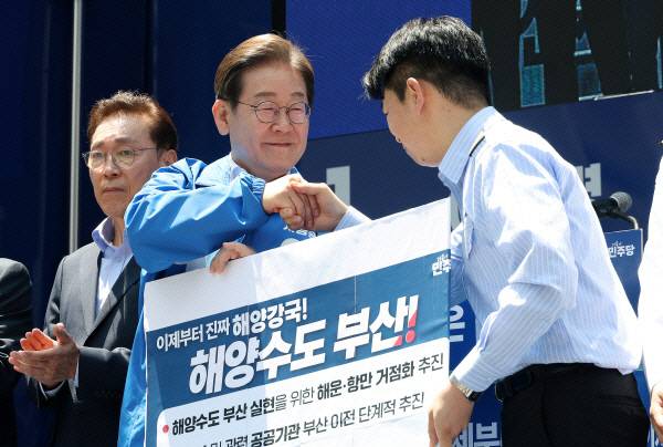 더불어민주당 이재명대선후보가 지난 14일 부산서면유세에서 해양수도부산 협약서에 서명한뒤 권기흥에이치라인 해운해상직원노조위원장과 악수하고 있다. 이원준 기자