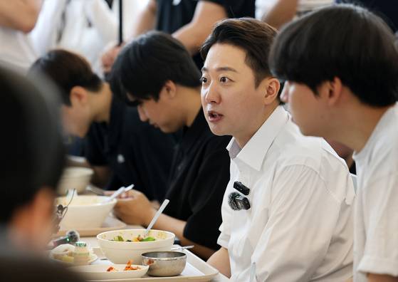 Reform Party presidential candidate Lee Jun-seok talks with students over lunch at Chonnam National University in Gwangju on May 20. [YONHAP]