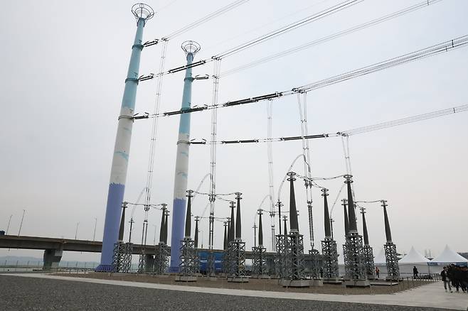 국내 최장기 송전망 지연 사업인 충남 북당진∼신탕정(아산) 345㎸ 송전선로 준공식이 지난달 2일 당진시 송악읍 인근 해상철탑에서 열렸다. 사진은 준공된 송전선로. 이 송전선로는 애초 2012년 6월 준공을 목표로 했으나, 주민 반대와 지방자치단체 인허가 지연 등으로 2014년 6월에야 아산 구간부터 공사를 시작할 수 있었다. [연합]