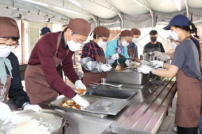 정인국 케이카 사장(좌측 두 번째)이 봉사자들과 함께 식사 준비를 돕고 있다. [케이카 제공]