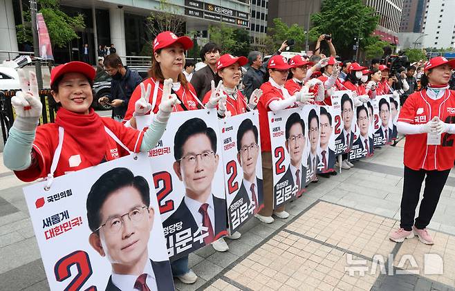 [서울=뉴시스] 고승민 기자 = 김문수 국민의힘 대선 후보가 19일 서울 청계광장에서 청년정책 발표를 하는 동안 선거운동원들이 환호하고 있다. 2025.05.19. kkssmm99@newsis.com