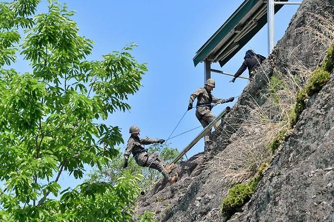 [서울=뉴시스] 육군은 23일 각 병과학교에서 '신임장교 지휘참모과정' 교육훈련에 매진 중인 장병들의 모습을 공개했다.육군보병학교 신임장교들이 유격훈련 중 산악장애물 극복을 위한 후면하강 훈련을 하고 있다. (사진=육군 제공) 2025.05.23. photo@newsis.com *재판매 및 DB 금지
