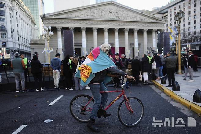 <font style="vertical-align: inherit;"><font style="vertical-align: inherit;">[부에노스아이레스=AP/뉴시스] 지난달 26일(현지 시간) 아르헨티나 부에노스아이레스에서 한 시민이 반려견을 업은 채 자전거를 타고 있다. 2025.05.23.</font></font>