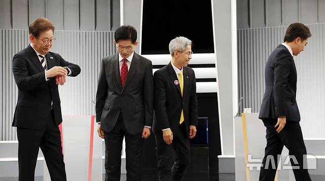 [서울=뉴시스] 국회사진기자단 = 23일 서울 영등포구 KBS본관 스튜디오에서 열린 중앙선거방송토론위원회 주관 제21대 대통령선거 2차 후보자 토론회 시작에 앞서 각 정당 대선후보들이 기념촬영을 마친 뒤 자리로 돌아가고 있다. 왼쪽부터 이재명 더불어민주당, 김문수 국민의힘, 권영국 민주노동당, 이준석 개혁신당 대선후보. 2025.05.23. photo@newsis.com