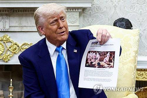 '남아공 백인 학살' 증거라며 기사 인쇄물 들어 보이는 트럼프 대통령 [로이터 연합뉴스]
