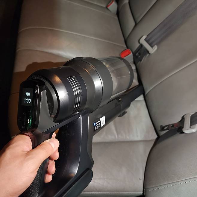 비스포크 AI 제트 400W으로 차량 뒷자석 시트 안쪽 먼지를 빨아들이는 모습. 언제부터 들어가 있었는지 알 수 없는 과자 봉지들이 줄줄이 빨려나왔다. 이동수 기자