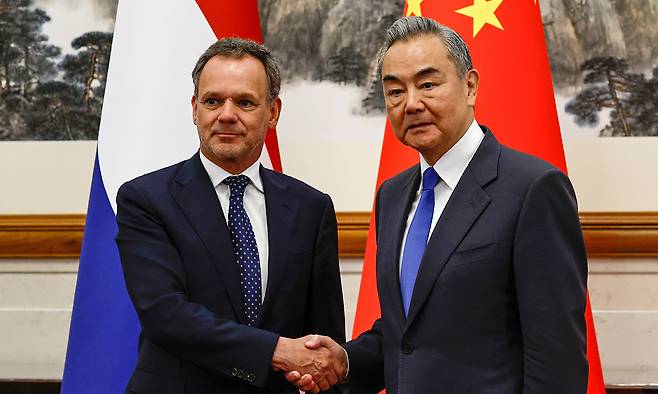 카스파 벨드캄프 네덜란드 외교장관(왼쪽)과 왕이 중국 외교부장이 22일(현지시간) 중국 베이징 댜오위타이 국빈관에서 회담에 앞서 악수하고 있다. 로이터연합뉴스