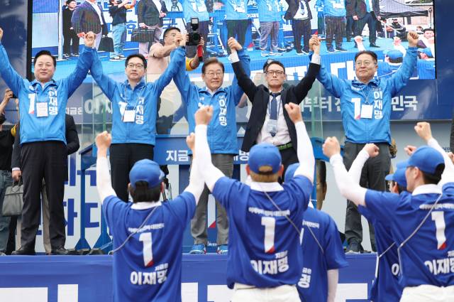 이재명 더불어민주당 대선 후보가 22일 경남 양산워터파크공원에서 열린 집중유세에서 김경수 총괄선대위원장 등과 손을 맞잡고 시민들을 향해 인사하고 있다. 연합뉴스