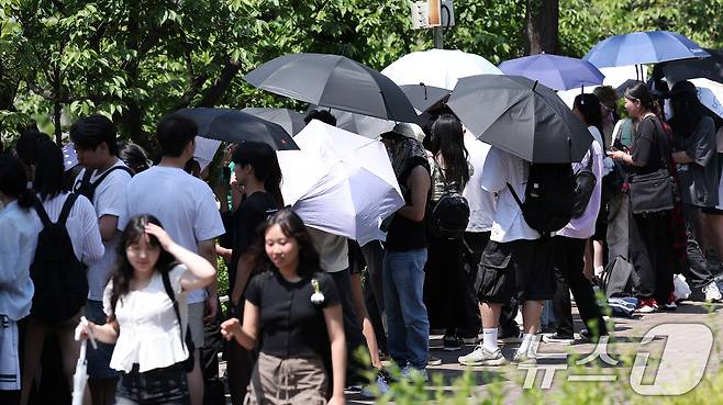 전국적으로 초여름 날씨를 보인 22일 서울 시내 한 대학교에서 학생들이 우산과 양산으로 햇빛을 가린 채 노천극장 입장을 기다리고 있다. 2025.5.22/뉴스1 ⓒ News1 김성진 기자