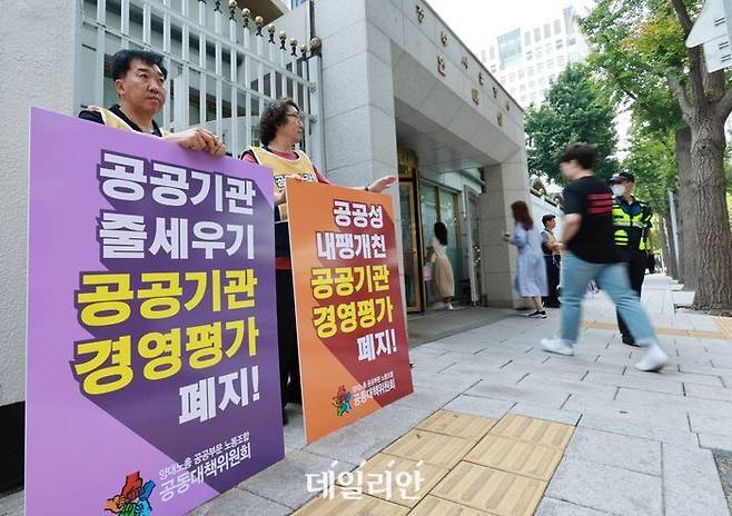 민주노총 공공운수노조, 한국노총 공공연맹 등 양대노총 공공부문 노조 공동대책위원회에 참여하고 있는 노조 조합원들이 공공기관 경영평가가 공공성보다 이윤을 최고 가치로 평가한다고 주장하며 제도 개선을 촉구하는 팻말 시위를 벌이고 있다.ⓒ연합뉴스