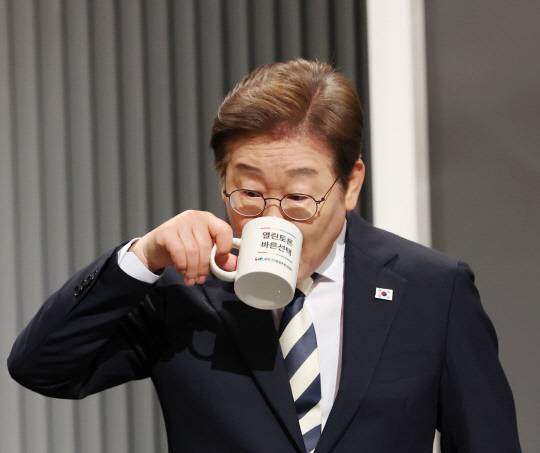 더불어민주당 이재명 대선후보가 지난 5월23일 서울 여의도 KBS 스튜디오에서 열린 제21대 대선 2차 후보자 토론회를 준비하며 목을 축이고 있다.<국회사진기자단·연합뉴스 사진>