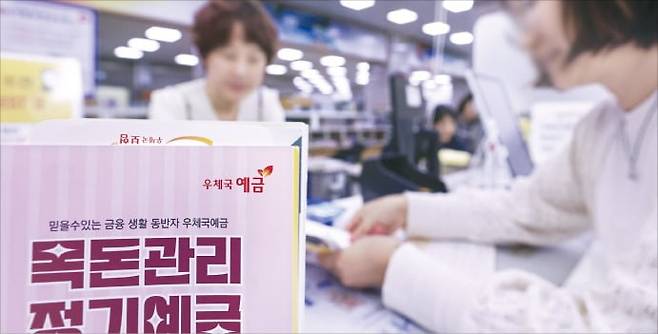 우체국예금 총자산이 지난해 사상 처음으로 100조원을 넘어섰다. 작년 한 해에만 4조원의 예·적금을 빨아들였다. 23일 서울 시내 한 우체국 창구에서 고객이 상담하고 있다.   /임형택 기자