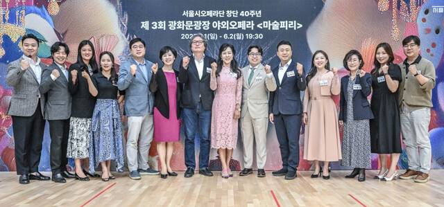 지난 20일 세종문화회관에서 열린 제3회 광화문광장 야외 오페라 ‘마술피리’ 기자간담회에서 박혜진(오른쪽에서 일곱 번째) 서울시오페라단 단장이 성악가들, 연출가, 지휘자, 시민 합창단 단장들과 파이팅을 외치는 모습. 세종문화회관 제공